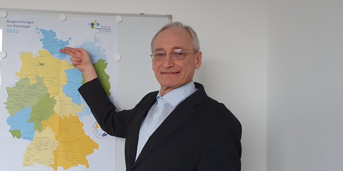 Dr. Michael Eckstein vor der Karte der Bürgerstiftungen mit Gütesiegel 2022